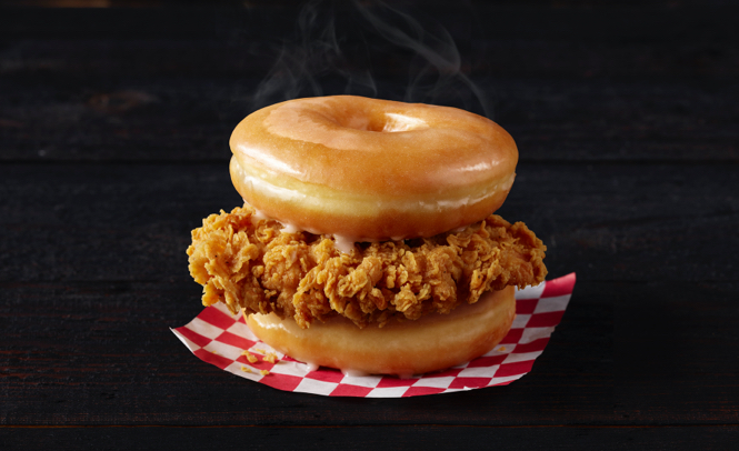 Piece of fried chicken breast between two glazed donuts